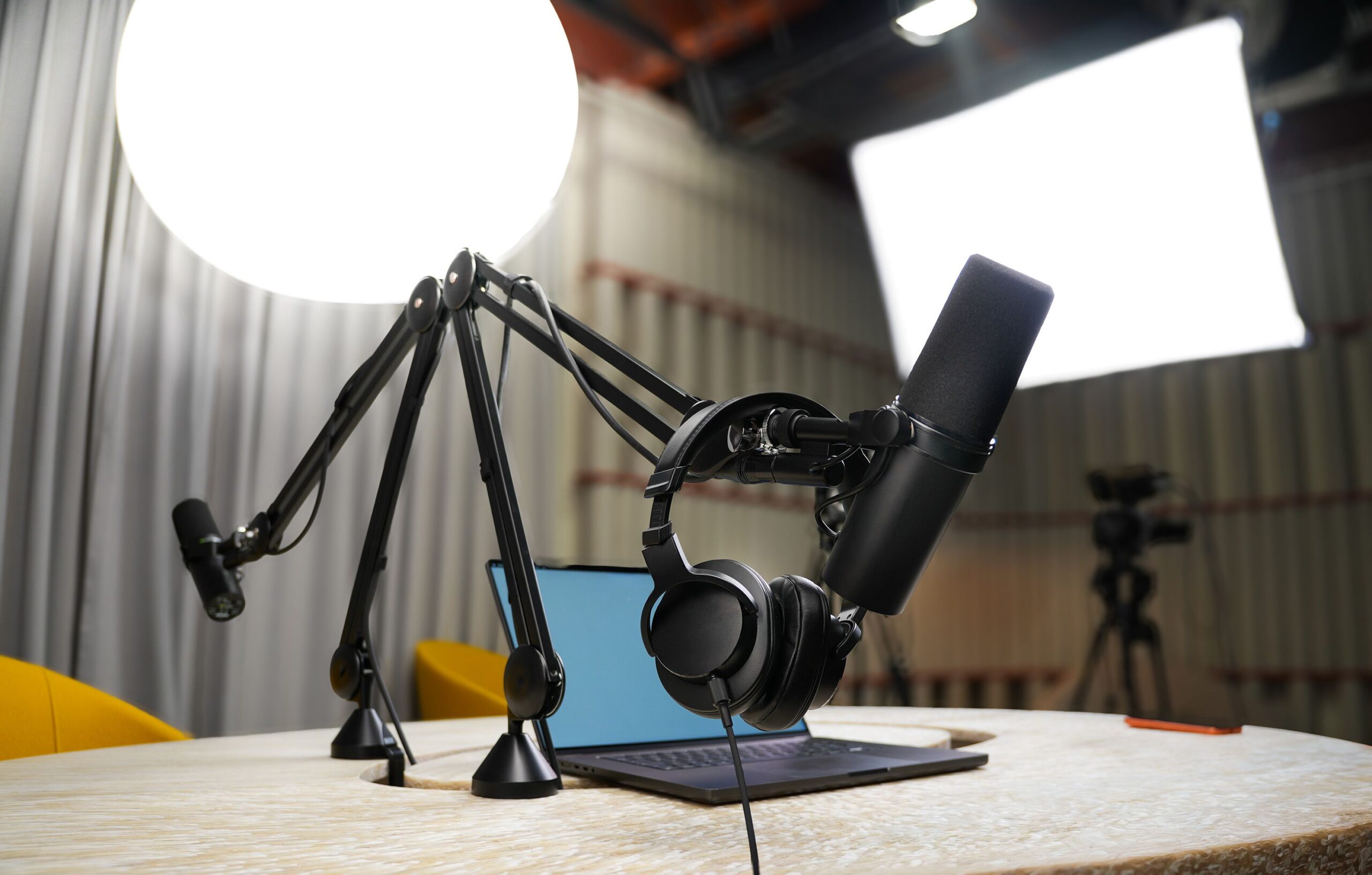 Podcast Studio mit Shure SM7B Mikrofonen, Kopfhörern und Filmbeleuchtung im Hintergrund